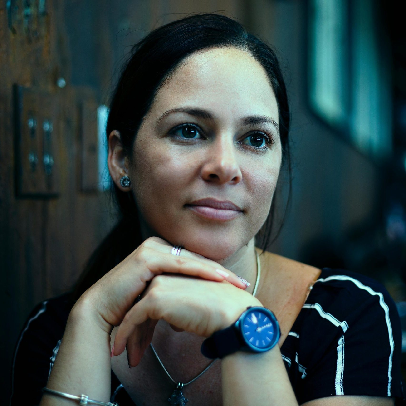 Casual portrait of a young Hispanic woman in a Miami café, reflecting timeless elegance.